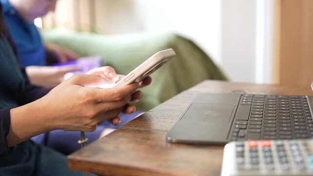 Mother working on smartphone and laptop at home while son playing video games, remote work, digital parenting, family lifestyle and work life balance concept,Mother and son spending time together