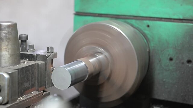 The lathe is located in the production hall. An electric lathe removes a layer from a piece of metal covered with rust, giving a picture of the product. Manufacture of metal products.