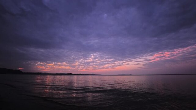 Dark moody seascape at dusk with island silhouettes and layered clouds
