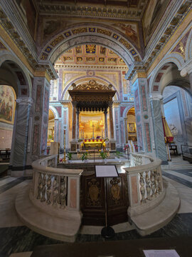 High altar with ornate baldachin and marble balustrade inside the historic Basilica of San Nicola in Carcere, Rome