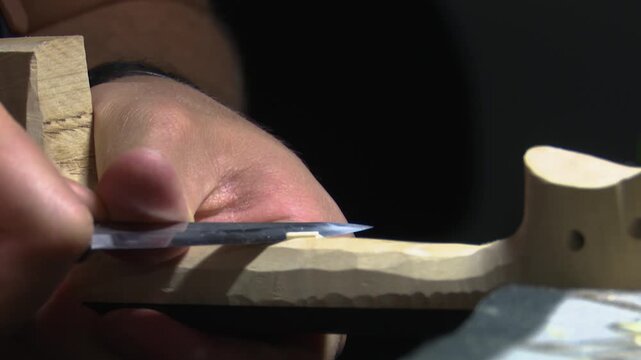 Bilbao, spain; may 21 2022: luthier craftsman carving wooden violin neck