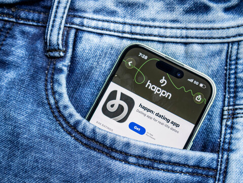 Smartphone showing the happn dating app store page inside a blue denim jeans pocket
