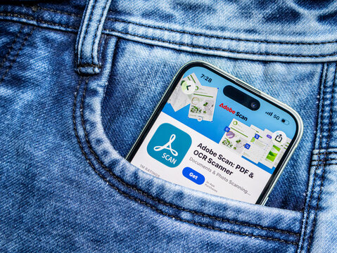 Smartphone showing adobe scan app page in a blue denim jeans pocket