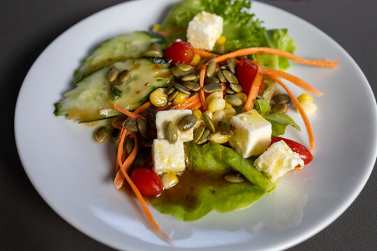Delicious Plate of Healthy Salad with Lettuce, Carrots, Cucumbers, Tomatoes, Peppers, Feta and Sunflower Seeds