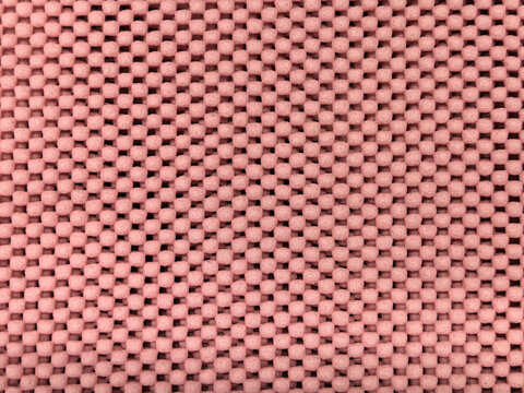 Pink rubber non-slip mat texture with small raised round dots pattern