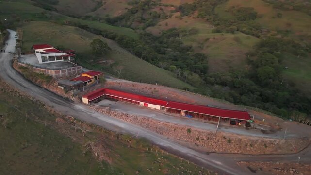 Aerial view of rural farm buildings and stables in the mountains at sunset