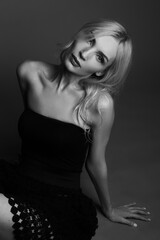 Naklejka premium Sensual Fine Art Black and White Portrait of a Blonde Female Model Sitting on the Floor, Studio Fashion Photography