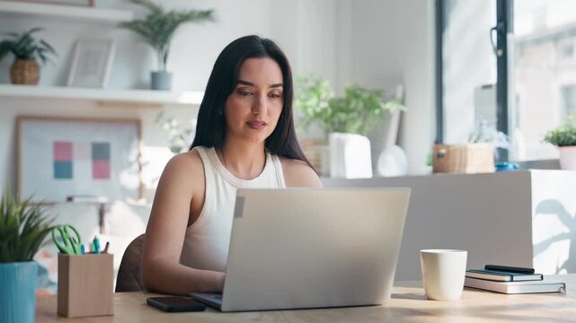 Video of beautiful woman working with laptop in the livingroom at home