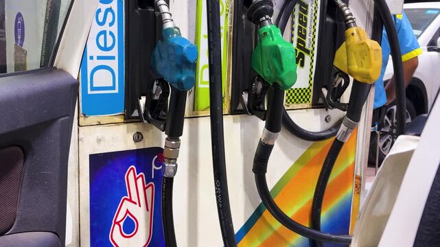 petrol station dispenser machine featuring colorful fuel pump handles close up