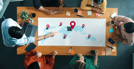 Diverse team members gather in an office setting to discuss business strategies using a digital map with location pins, highlighting ideas for global expansion and collaboration. Gantry © InfiniteFlow