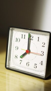 Woman reaching for her alarm clock after waking up in bed at home