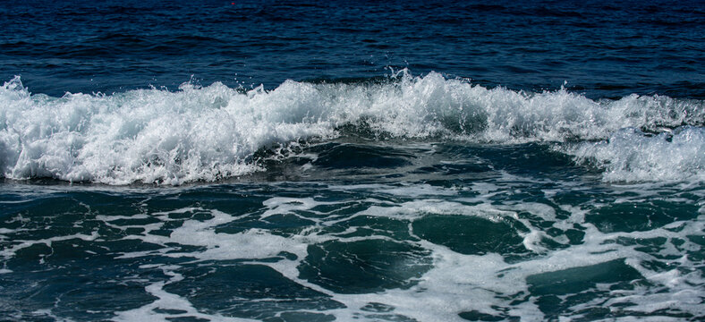 Waves ocean texture. Sea waves move. Foamy sea wave with oceanic power. Sea waves curl and break on the coast.