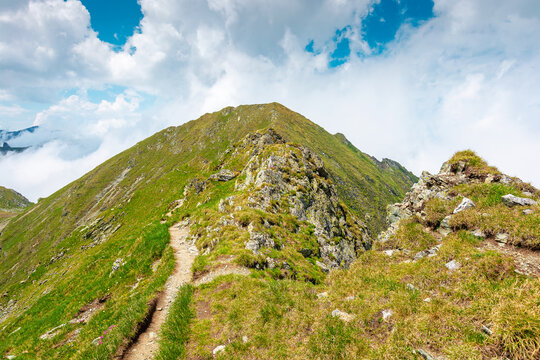 romania mountain scenery in summer. gorgeous mountainous landscape of carpathians. background with rocky cliffs and grassy hillsides under a cloudy sky. fagaras ridge of southern carpathian mountains