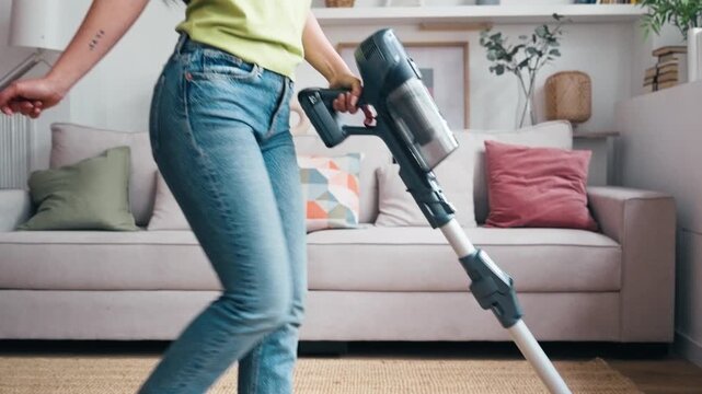 Video of happy woman dancing and singing while vacuuming at home