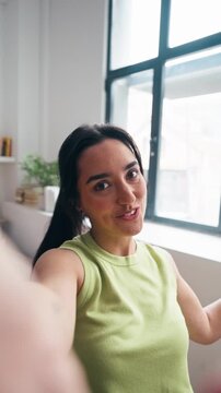 Video of happy woman doing a videocall with smartphone in the living room at home