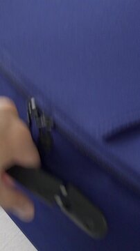 Unrecognizable businessman showing Euros passport on a blue suitcase on a bed