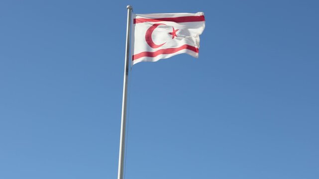 Turkish Republic of Northern Cyprus Flag waving in blue sky. Northern Cyprus.