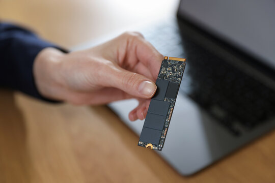 Woman with SD RAM at wooden desk, closeup