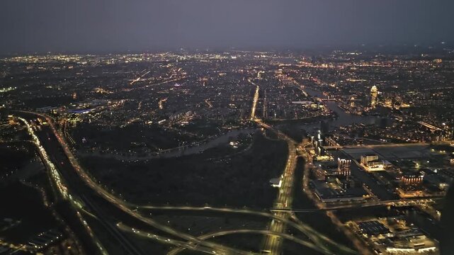 A plane approaches Schiphol Airport for landing. A view of Amsterdam in the late evening. 
