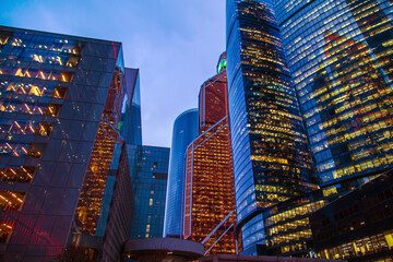 Fototapeta premium Bottom-up view of the skyscrapers of the Moscow City business center. Modern glass office buildings at night.