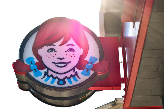 Low angle view of Wendy&rsquo;s restaurant logo and storefront signage against the sky, showing recognizable fast food branding in May 2026
