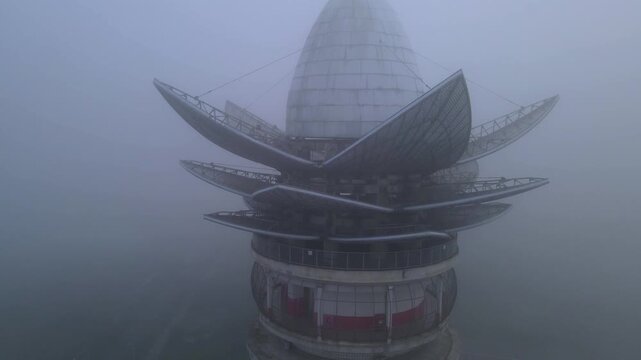 Aerial view of Menara Pandang Teratai tower shrouded in thick fog and mist in Purwokerto, Jawa Tengah, Indonesia.