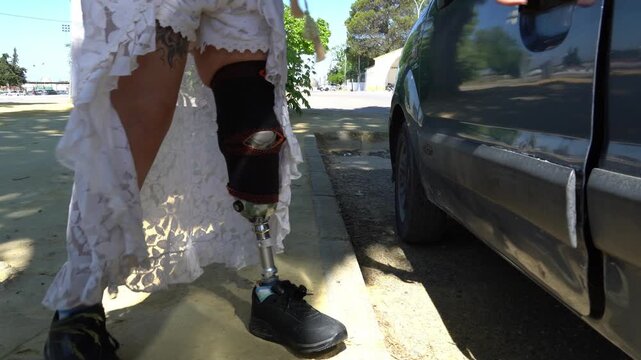 Determined woman with a prosthetic leg walking towards her car. She opens the door, gets inside, and closes it, showcasing independence