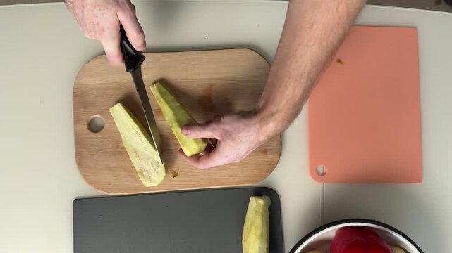Preparing Plantain Slices For Quick Side Dish. Cutting Plantains Into Uniform Pieces On Wooden Surface