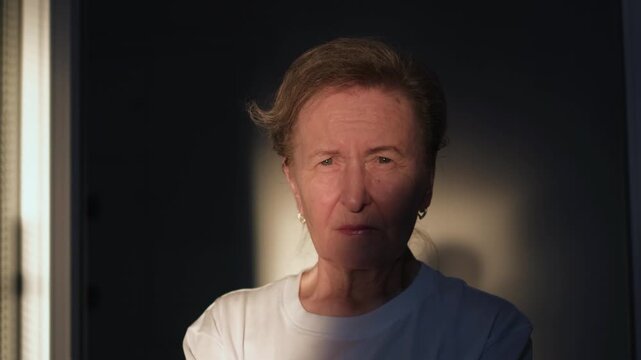 Portrait of a very old woman in a doorway at sunset