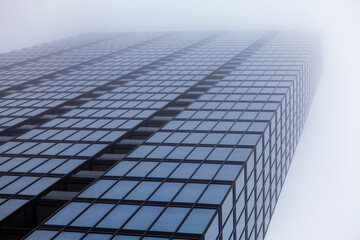 Fototapeta premium Glass skyscraper fading into fog
