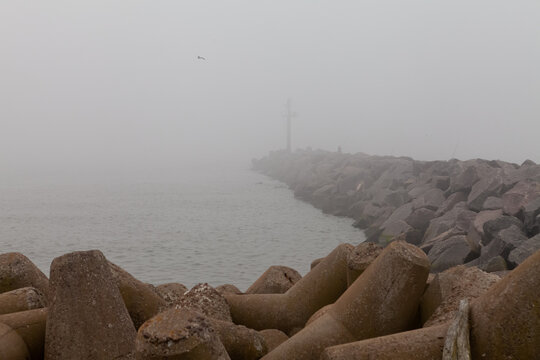 Foggy breakwater with concrete tetrapods by the sea