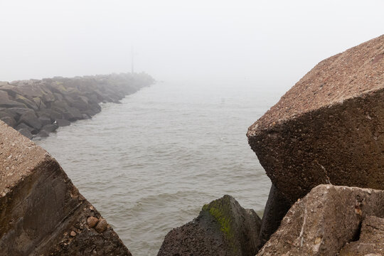 Foggy breakwater with concrete tetrapods by the sea
