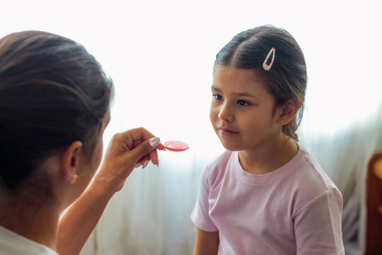 Madre dando medicina a su hija peque&ntilde;a
