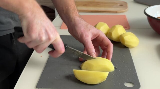 Potatoes Preparing Scene. Closeup Of Chef Slicing Potatoes Into Even Pieces On Small Chopping Board