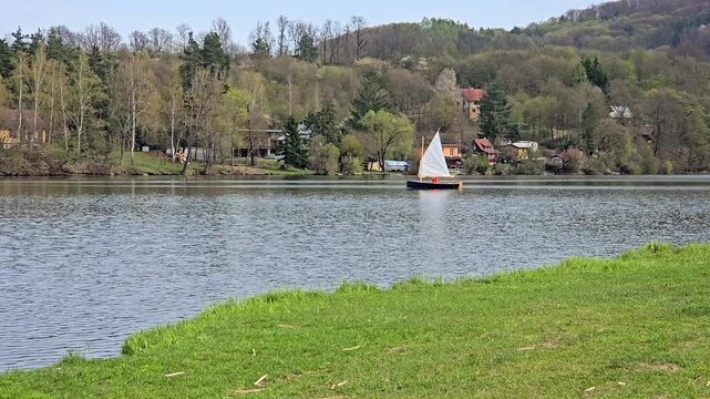 Small Sailboat on a Calm Lake with Mirror Reflection