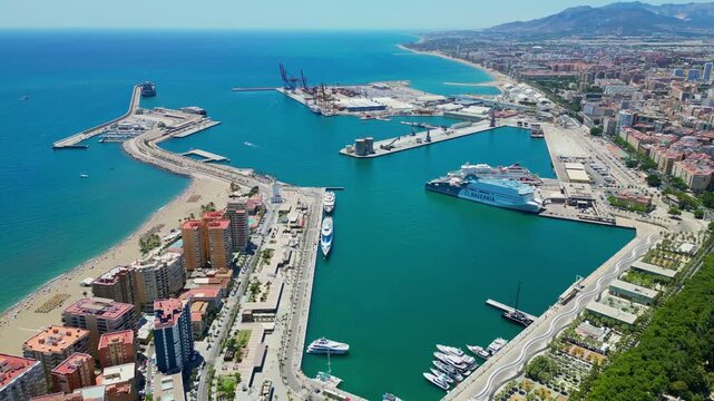 Malaga, Spain - July 17, 2025 High angle flyover of Malaga harbor and the historic Gibralfaro medieval fortress on the hilltop. Scenic coastal cityscape with luxury boats and Mediterranean sea in Anda