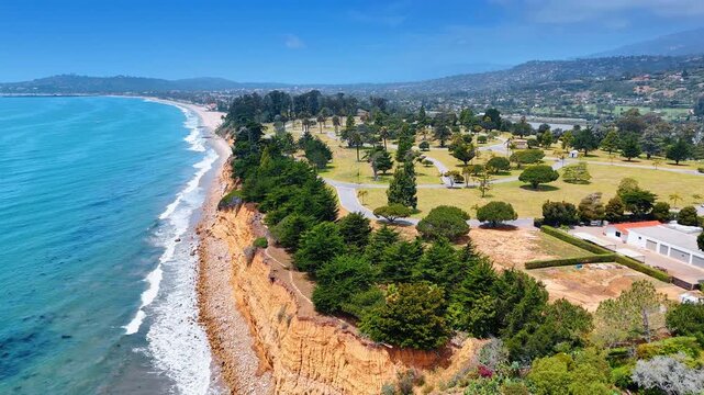 Flight over the cliffside shore with beautiful lush greenery on. Picturesque scenery of Montecito area of Santa Barbara, California, USA.