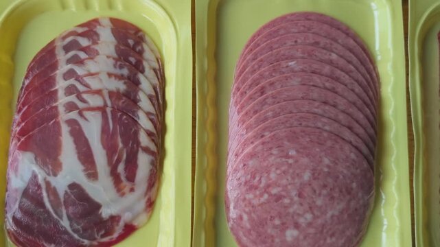 Sliced meats displayed in yellow trays, showcasing progression from whole cuts to thinly sliced varieties, highlighting texture and color variations in a food presentation setting