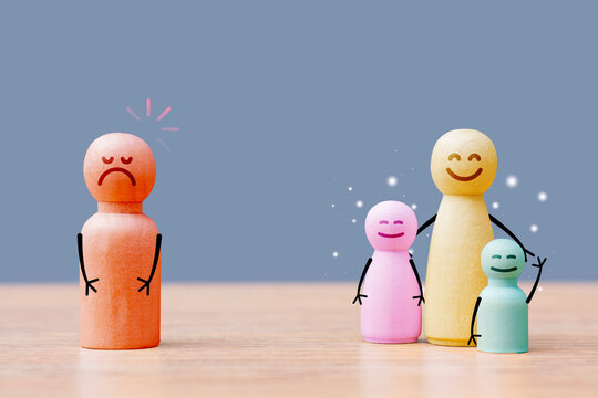 Social exclusion, divorce and family conflict concept with sad and happy wooden figures on blue background. Mental health, parenting, separation, custody or relationship communication banner.