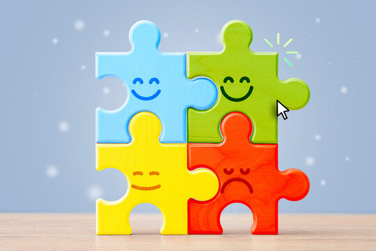 Colorful wooden puzzle pieces with smiling and sad faces on blue background. Teamwork, emotions, problem solving and business connection concept for education, psychology and collaboration.