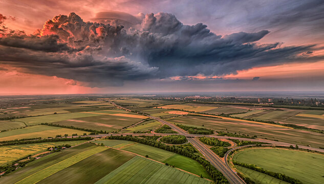 Sunset supercell storm above agricultural landscape aerial view
Dramatic storm cloud illuminated by sunset above rural fields and highway network captured from drone perspective.
