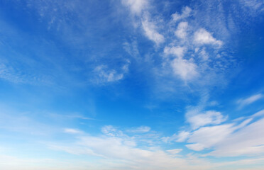 Obraz premium Beautiful blue sky background with light white cirrus clouds on a sunny day.
