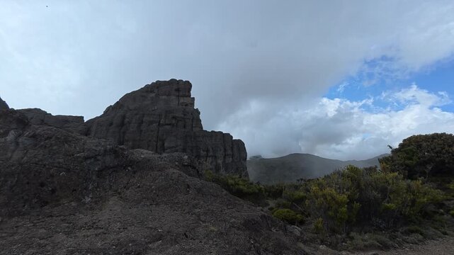 Cinematic panning shot of Cerro Crestones in Chirripo National Park, Costa Rica, with dramatic mist and clouds passing over the rugged peaks and Terbi trail. High-altitude mountain B-roll.