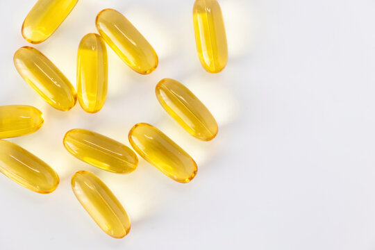 Yellow omega 3 fish oil capsules isolated on white background with copy space. Nutritional supplement and healthcare concept in minimal style.