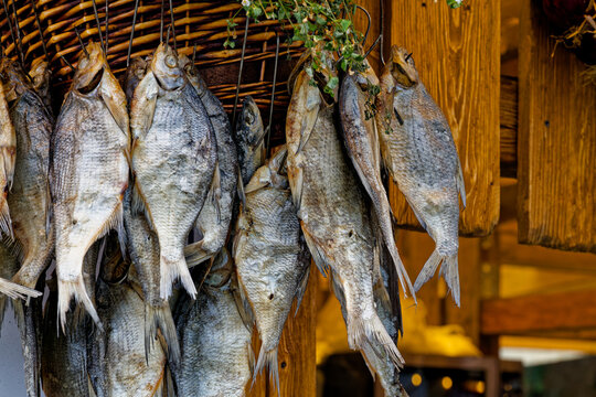 Rustic fish hung to dry on woven racks. A coastal tradition, captured through traditional methods of preparing fish dishes