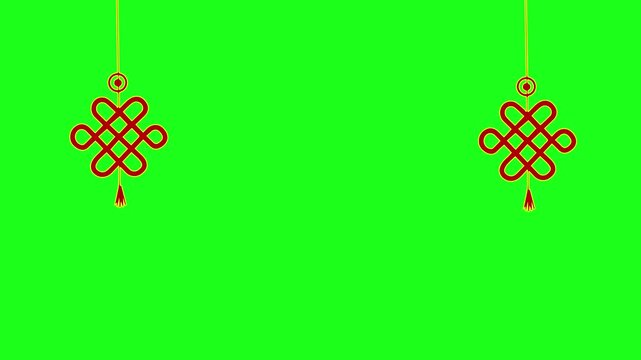 Two hanging red Chinese knots swaying gently on a green screen background. Traditional Lunar New Year decoration