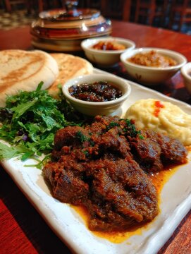 Ethiopian kitfo leb leb dish with spiced butter and mitmita served in a restaurant setting