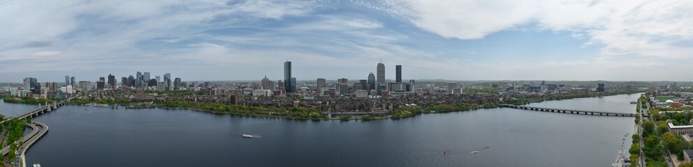 Obraz premium Panoramic aerial drone view of Boston Back Bay skyline, Prudential Tower, and Charles River Esplanade on a clear summer day, featuring historic brownstones and city skyscrapers, USA.