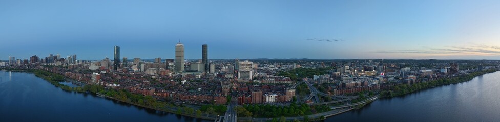 Obraz premium Panoramic aerial drone view of Boston Back Bay skyline, Prudential Tower, and Charles River Esplanade on a clear summer day, featuring historic brownstones and city skyscrapers, USA.