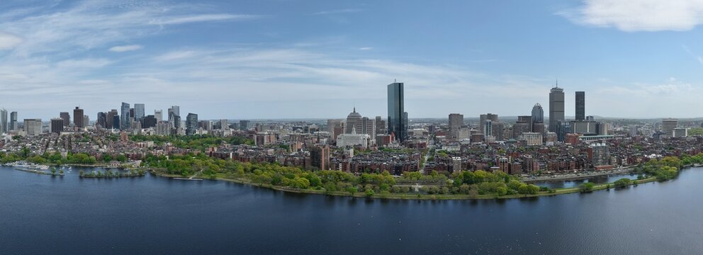 Panoramic aerial drone view of Boston Back Bay skyline, Prudential Tower, and Charles River Esplanade on a clear summer day, featuring historic brownstones and city skyscrapers, USA.